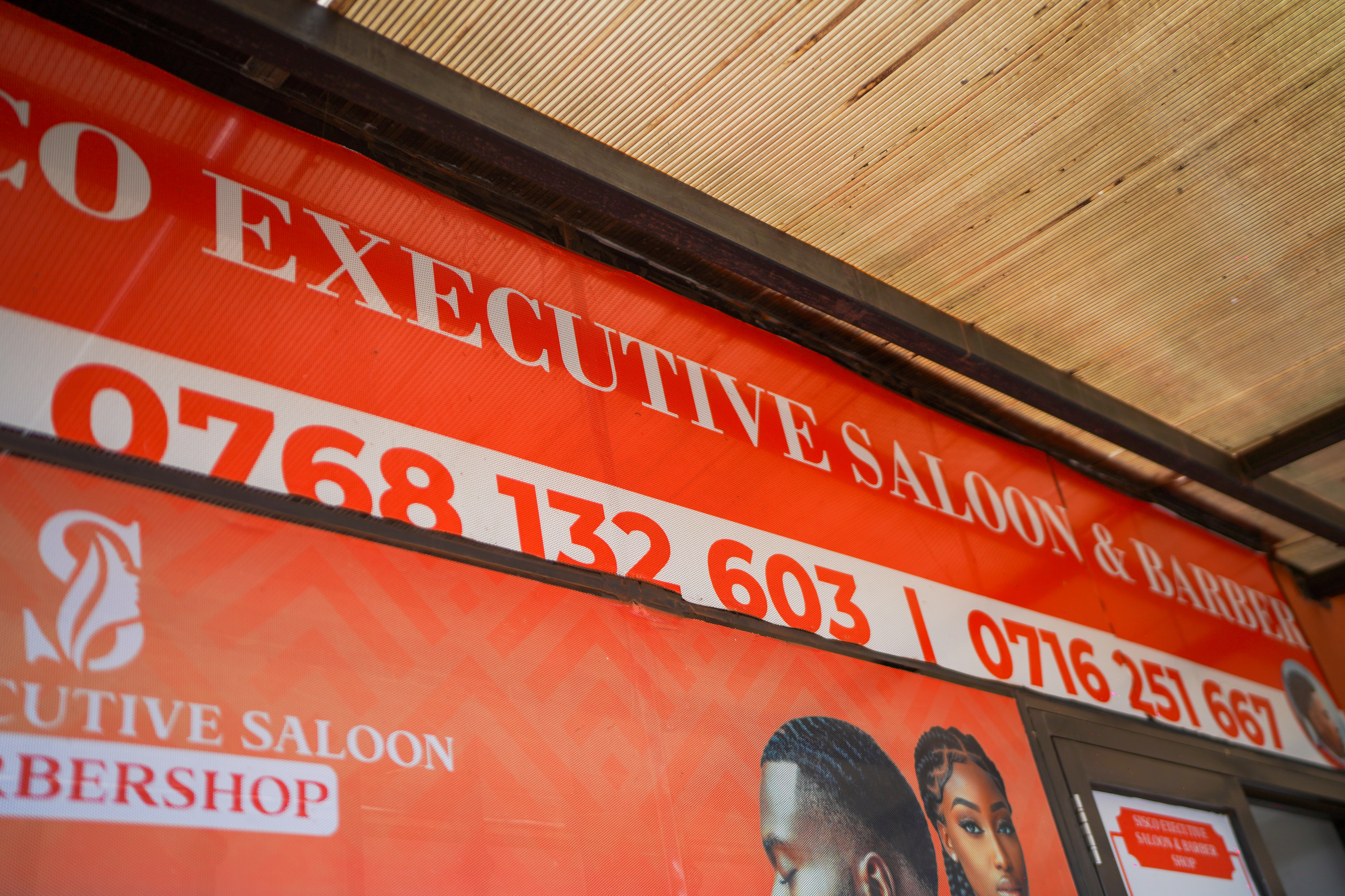 Sisco Executive Saloon & Barber — exterior banner with phone numbers